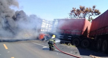 Mulher morre carbonizada após carro colidir contra duas carretas na BR-365 Mulher morre carbonizada após carro colidir contra duas carretas na BR-365