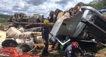 Motorista fica preso às ferragens após bitrem sair da pista e capotar na MGC- 354