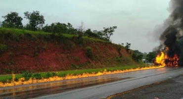 Carreta tanque com 44 mil litros de combustível tomba e pega fogo na Curva dos Moreiras da BR-365