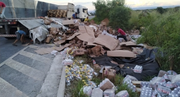 Carreta tomba na BR-146 e carregamento de cachaça fica espalhado pela rodovia 