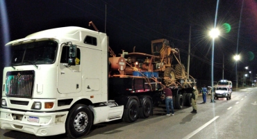 Carreta transportando pá carregadeira arrasta fiações e derruba poste no centro de Patos de Minas