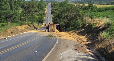 Caminhão tomba na BR-354 próximo à ponte sobre o córrego São Bartolomeu e carga de soja fica espalhada pela pista